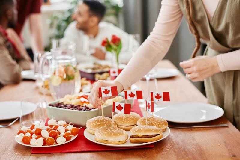 Immigrants dégustant des plats typiques de la gastronomie québécoise, mettant en avant les traditions culinaires et les saveurs locales.